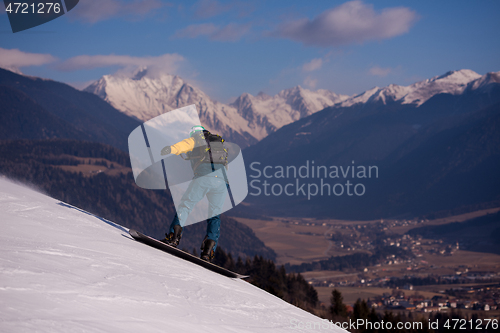 Image of snowboarder running down the slope and ride free style