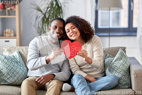 Image of happy african american couple with heart at home