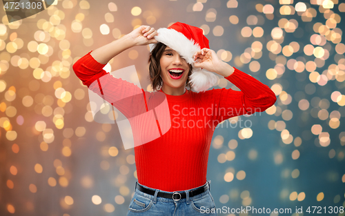 Image of happy young woman in santa hat on christmas