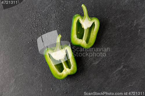 Image of cut green pepper on slate stone background