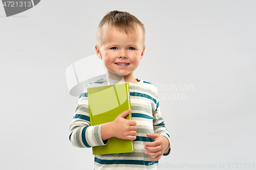 Image of portrait of smiling boy holding book