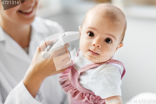 Image of doctor with thermometer measures baby temperature