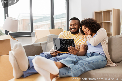 Image of happy couple with tablet pc computer at new home