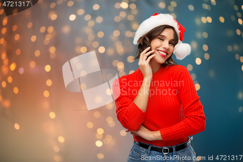 Image of happy young woman in santa hat on christmas