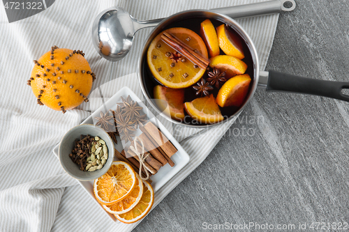 Image of pot with hot mulled wine, orange slices and spices