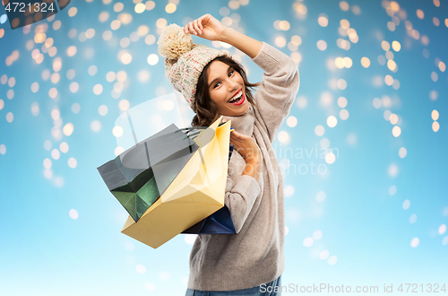 Image of young woman in winter hat with shopping bags