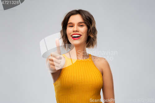 Image of happy smiling young woman showing thumbs up