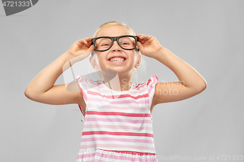 Image of smiling cute little girl in black glasses