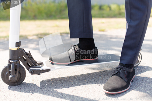 Image of young businessman with electric scooter outdoors