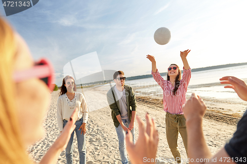 Image of friends playing volleyball on beach in summer