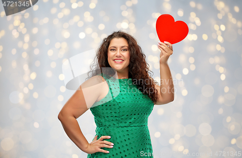 Image of happy woman holding red heart over lights