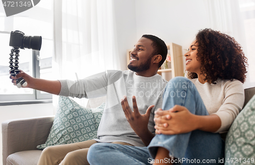 Image of couple of video bloggers with camera at home