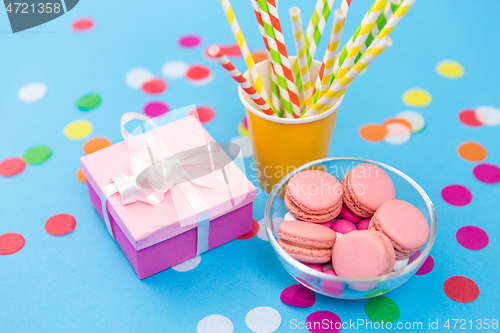 Image of birthday gift, macarons and paper straws for party