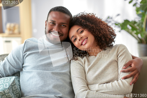 Image of happy african american couple hugging at home