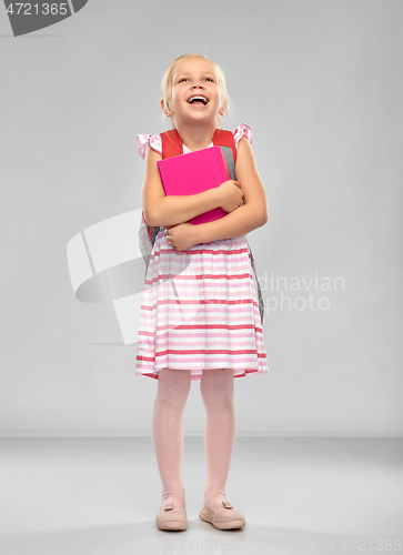 Image of happy little student girl with school bag and book