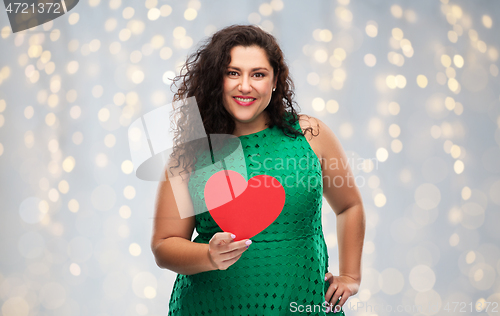 Image of happy woman holding red heart over lights