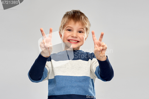 Image of little boy in striped pullover showing peace