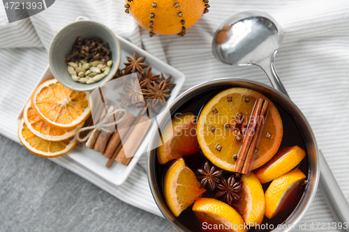 Image of pot with hot mulled wine, orange slices and spices