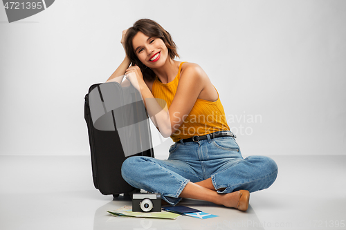 Image of woman with travel bag, air ticket, map and camera