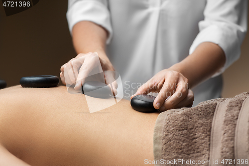 Image of close up of woman having hot stone massage at spa