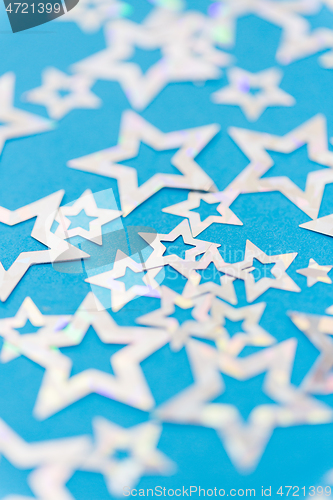 Image of star shaped confetti decoration on blue background