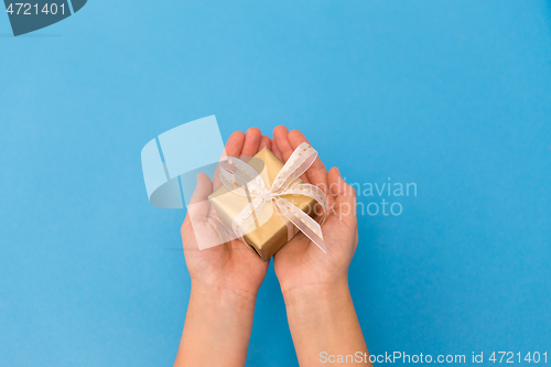 Image of hands holding small christmas gift box