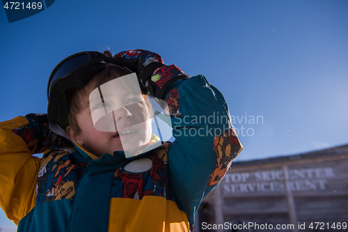 Image of little boy having a problem with ski goggles