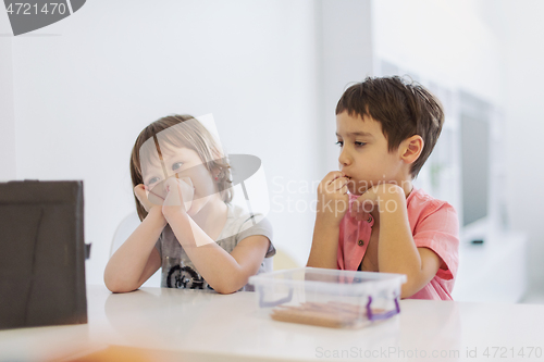 Image of cute little brother and sister having fun at home