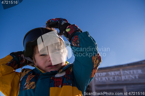 Image of little boy having a problem with ski goggles