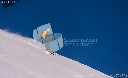 Image of snowboarder running down the slope and ride free style