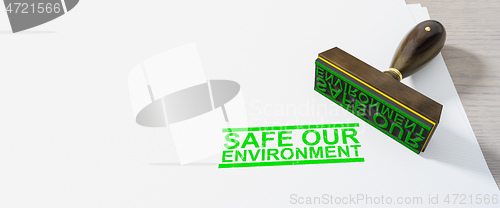 Image of green safe our environment stamp on white paper background