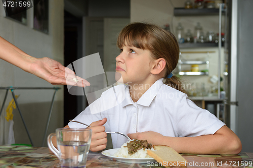 Image of Girl refuses to take medicine before dinner