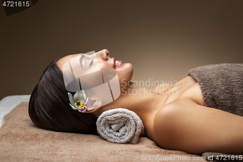 Image of young woman lying at spa or massage parlor