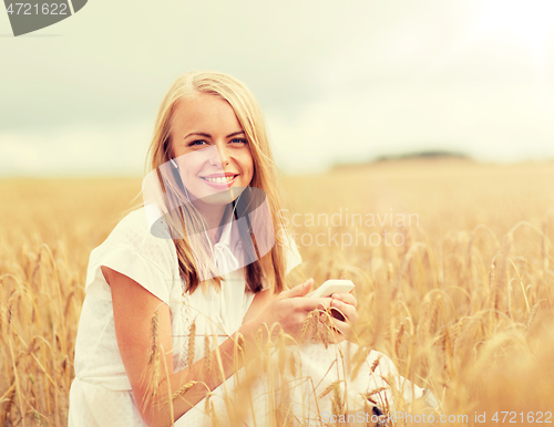 Image of happy woman with smartphone and earphones