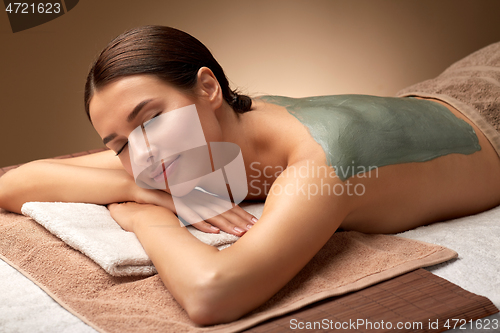 Image of woman with blue clay mask on her back at spa