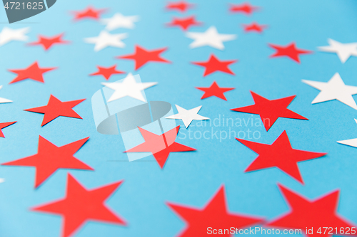 Image of star shaped confetti decoration on blue background