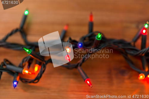 Image of christmas garland lights on wooden background