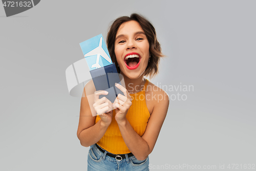 Image of happy young woman with air ticket and passport