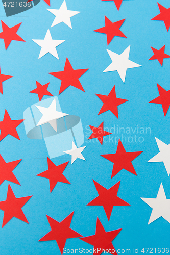 Image of star shaped confetti decoration on blue background