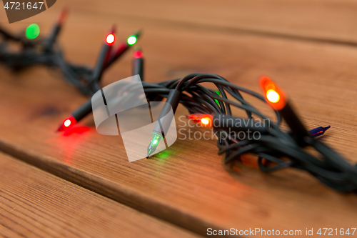 Image of christmas garland lights on wooden background