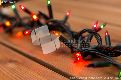 Image of christmas garland lights on wooden background