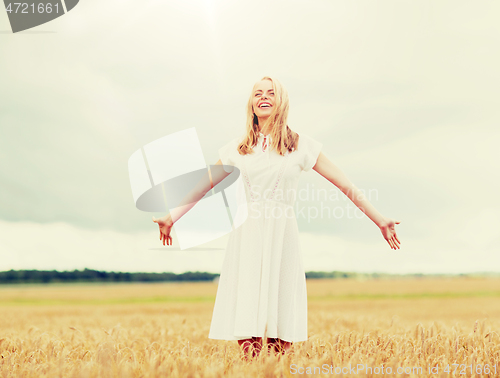 Image of smiling young woman in white dress on cereal field