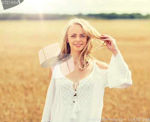 Image of smiling young woman in white dress on cereal field