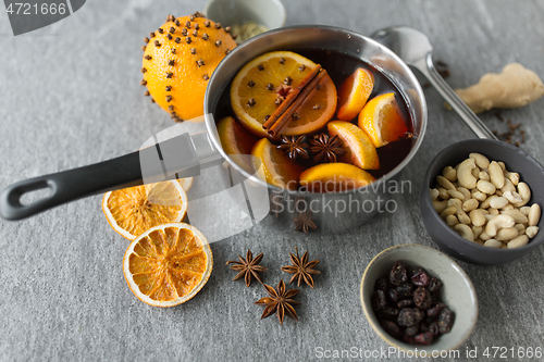 Image of pot with hot mulled wine, orange slices and spices