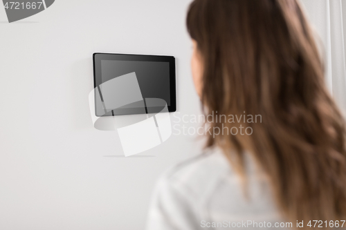 Image of woman looking at tablet computer at smart home