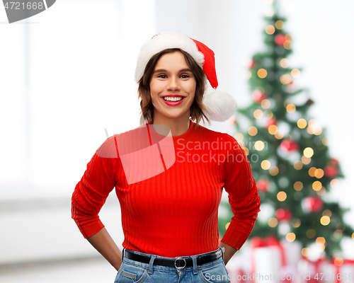 Image of happy young woman in santa hat on christmas