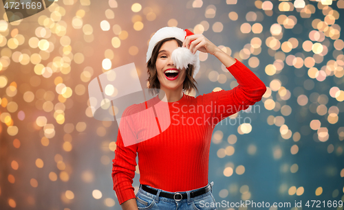 Image of happy young woman in santa hat on christmas