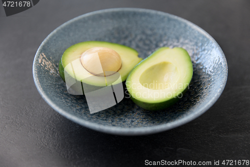 Image of close up of ripe avocado with bone in ceramic bowl