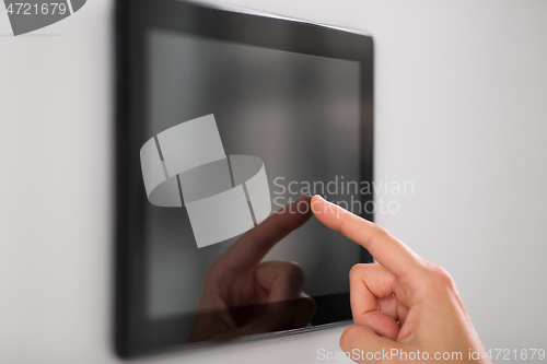 Image of hand using tablet computer at smart home