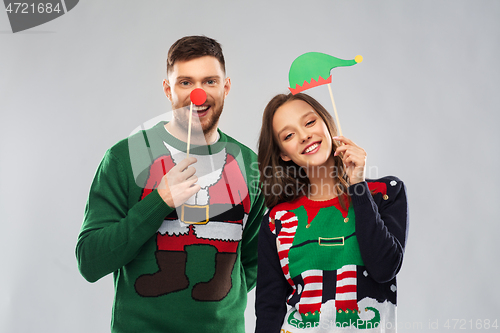 Image of couple with christmas party props in ugly sweaters